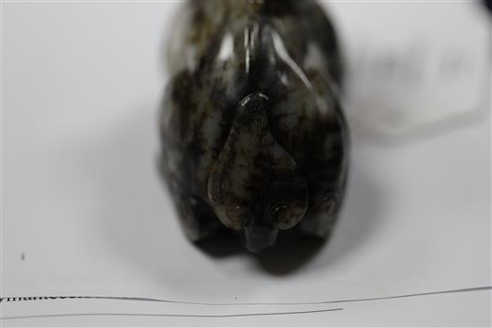 A Chinese pale grey and black jade recumbent figure of a lion-dog, length 8.3cm